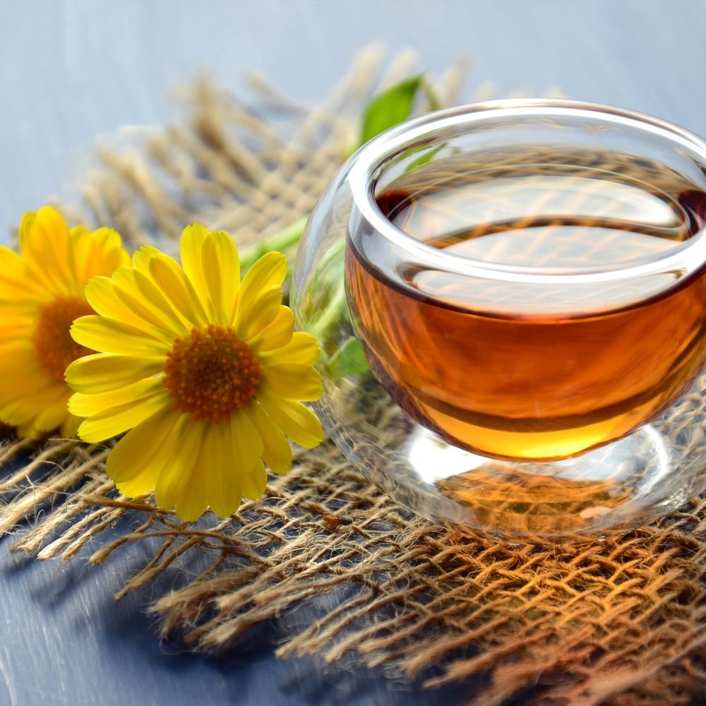 Cup of herbal tea with calendula flowers