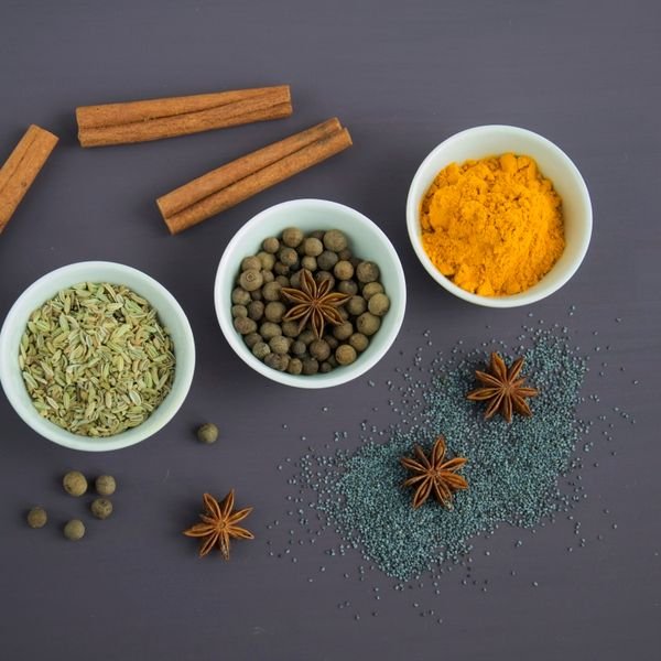 Ayurvedic spices including turmeric and cinnamon in small bowls