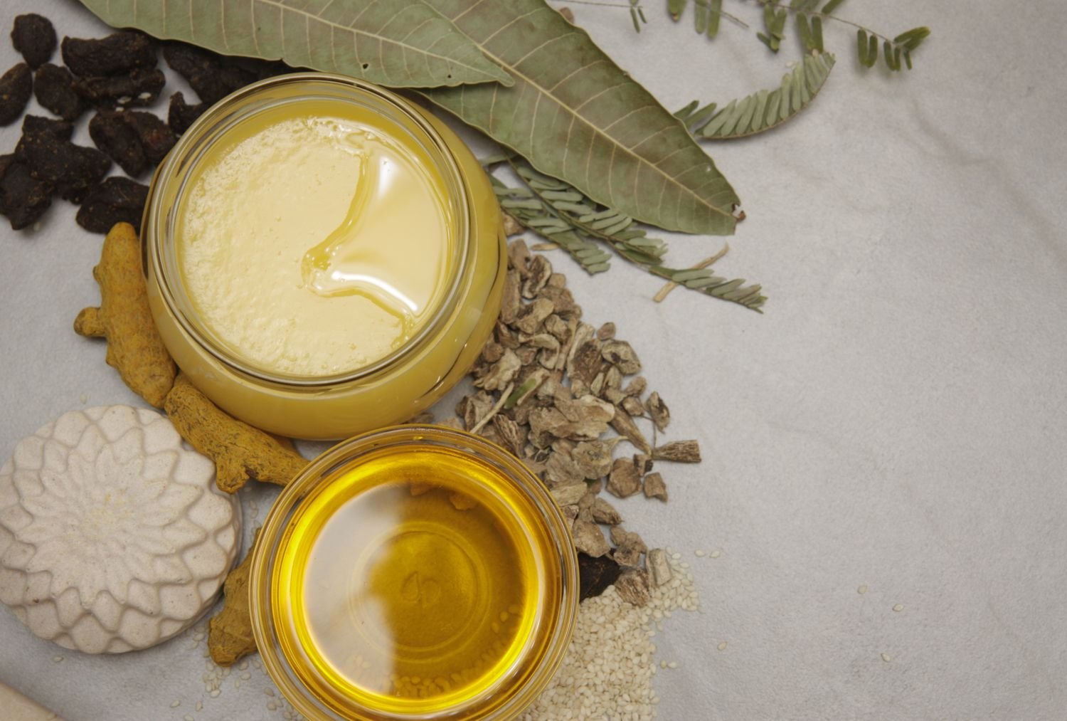 Ghee, oil, turmeric root and dried herbs used in traditional Ayurvedic preparations